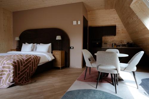 a bedroom with a bed and a table and chairs at Hotel Bent in Oisterwijk