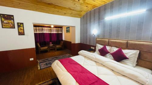 a bedroom with a large bed with purple pillows at Hill-Top With Open Terrace , 100mtr From Mall Road in Manāli