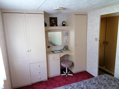 a bedroom with a desk and a mirror and a bed at Medumi Lake Caravan in Medumi