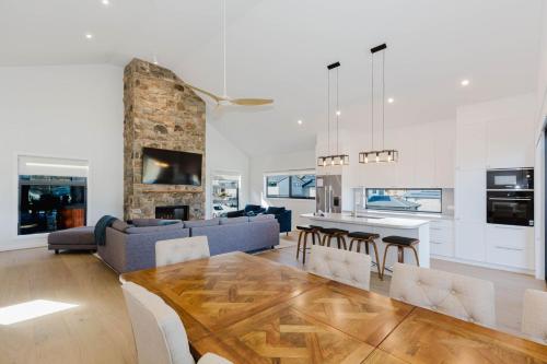 a kitchen and living room with a table and chairs at Rawson Retreat - Spa, EV outlet and Premium Luxury in Jindabyne