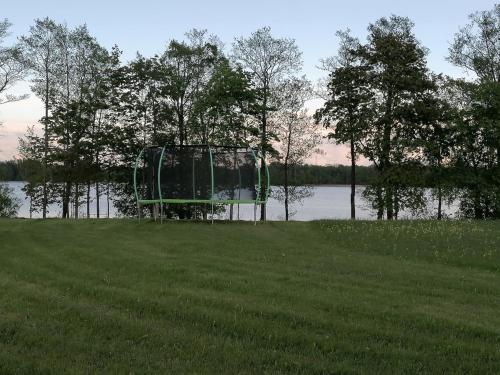 a green object sitting in the grass near a lake at Medumi Lake Caravan in Medumi