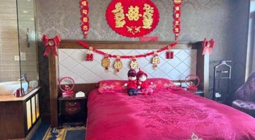 a bedroom with a large pink bed with red decorations at Hohhot Inner Mongolia Hotel in Hohhot