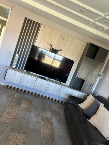 a living room with a large flat screen tv at Knovi Guesthouse in Bulawayo