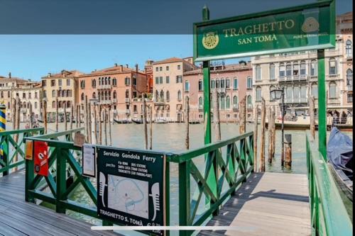 a sign on a bridge over a river with buildings at Domus Estia in Venice