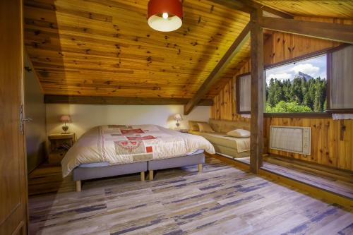 a bedroom in a log cabin with a bed and a window at Au coeur des Soms en Chartreuse in Saint-Pierre-de-Chartreuse