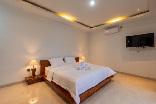 a bedroom with a bed with a teddy bear on it at Adis Villa, Cozy Private Stay with Pool , near ubud & sanur in Darmasaba