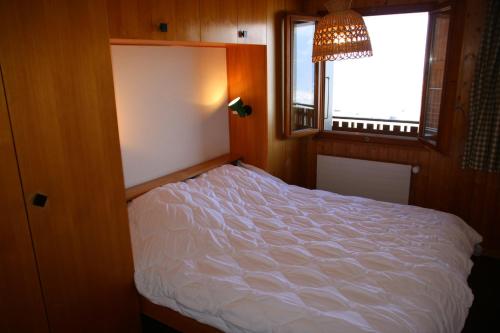 a bed in a room with a window at Iris I 031 - CONFORTABLE apartment 6 pers in Veysonnaz