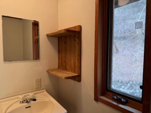 a bathroom with a sink and a mirror and a window at Cabin A MtFuji view, BBQ, lake Saiko 3mins, hammock, wood deck in Narusawa