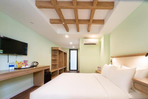 a bedroom with a large bed and a television at Nicecy Hotel - Trương Quyền in Ho Chi Minh City