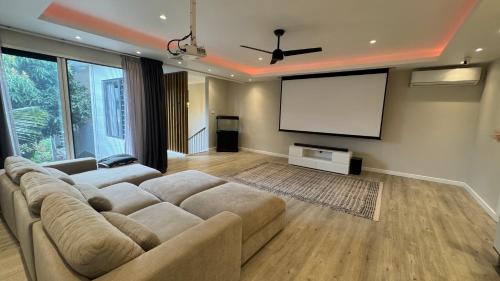 a living room with a large couch and a screen at Fully Furnished and Modern House in Mauritius in Quatre Bornes