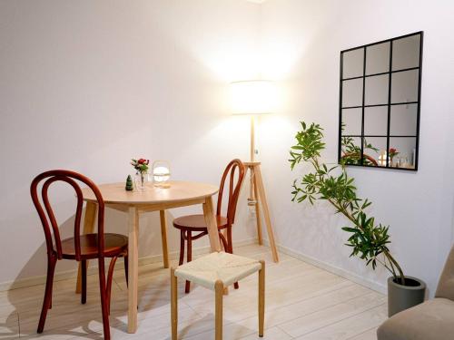 a table and chairs in a room with a lamp at OPEN! TOKYO Kitasenju A Newly built stylish room! in Tokyo
