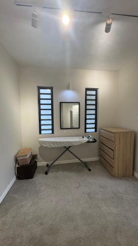 a room with a table and a mirror and windows at Fully Furnished and Modern House in Mauritius in Quatre Bornes