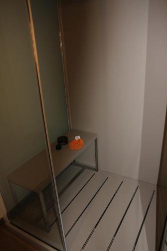 a glass shower stall with an orange item on it at La Catiniere in Arnage