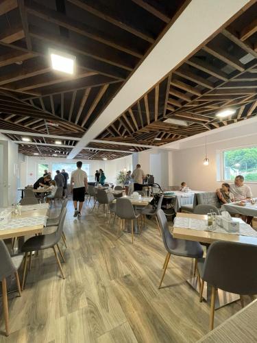 a restaurant with tables and people sitting at tables at Hotel Aurora in Băile Olăneşti