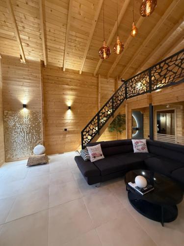 a living room with a black couch and a table at Casa del Corniolo in Čortanovci