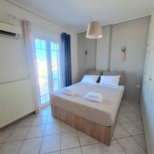 a bedroom with a bed with two towels on it at Athos Studios in Tinos Town