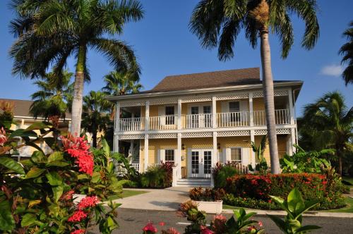 a house with palm trees and flowers at Sunshine Suites Resort in George Town