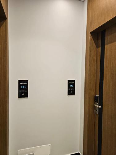 a bathroom with two clocks on the wall next to a door at Hotel Selavi in Sarandë