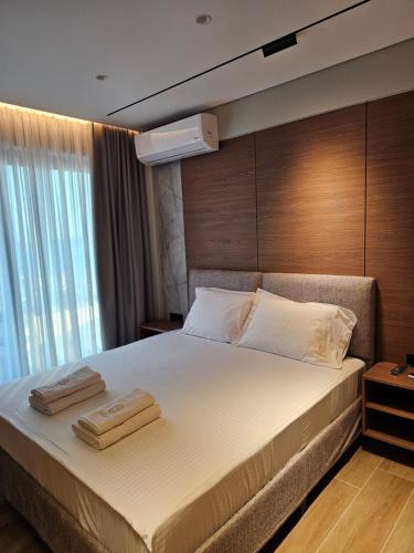 a bedroom with a large bed with two towels on it at Hotel Selavi in Sarandë