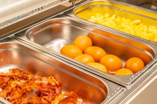 a metal tray filled with tomatoes and other food at Madi city Hotel in LʼAquila