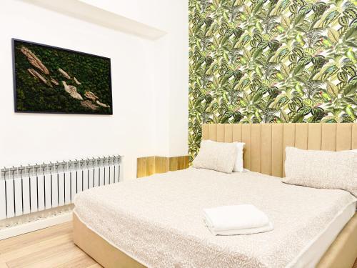 une chambre avec un lit et une peinture murale dans l'établissement Royal Max hotel & spa, à Almaty