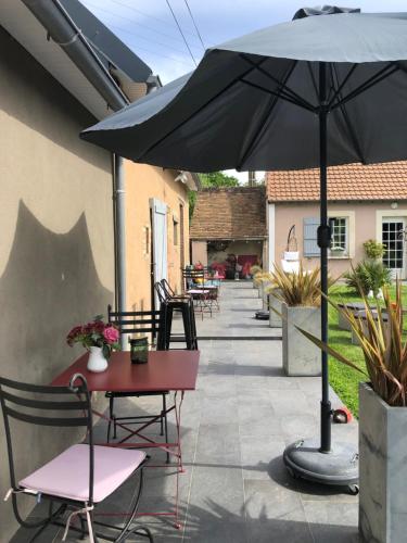 a patio with an umbrella and a table and chairs at La Catiniere in Arnage