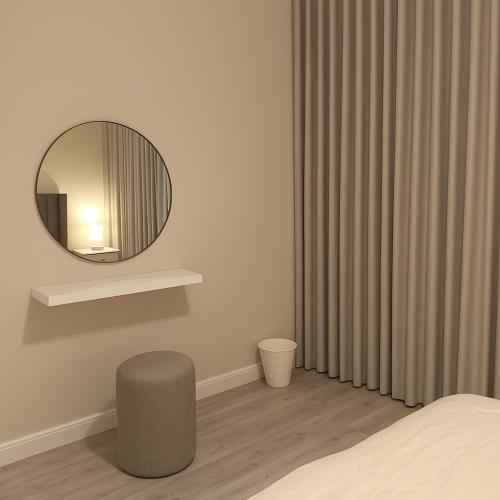 a bedroom with a round mirror and a bed at EMAAR Holiday Homes - Apartment 4 in Quai