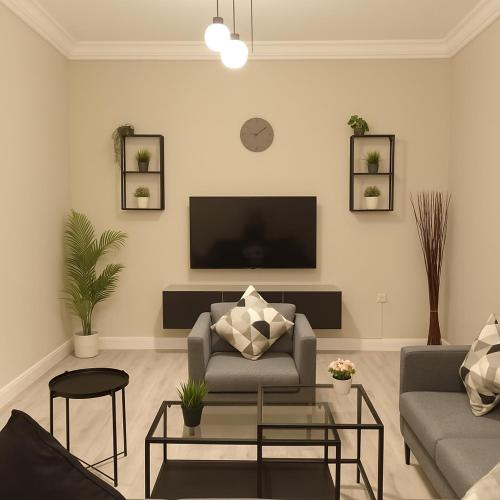 a living room with a couch and a tv at EMAAR Holiday Homes - Apartment 4 in Quai