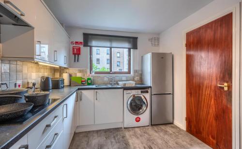 a kitchen with a refrigerator and a washing machine at Sharon Apartments Back Hilton in Aberdeen