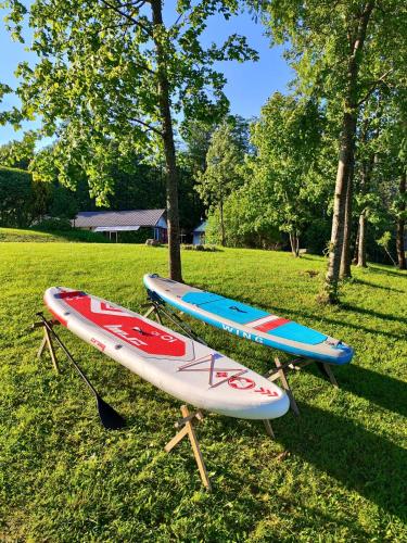 two kayaks on stand in the grass next to trees at Medumi Lake Caravan in Medumi