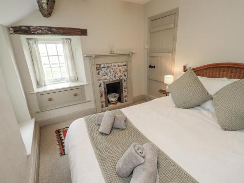 a bedroom with a bed with towels on it at Old Cottage in Ulverston