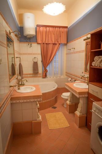 a bathroom with two sinks and a tub and a toilet at Apartment Bozic in Lovran