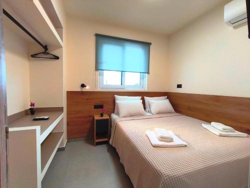 a bedroom with a bed with two towels on it at Villa Maroula in Afantou