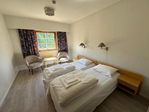 a bedroom with two beds and a desk and a window at Bjorliheimen Fjellhotell-Hotellrom in Bjorli