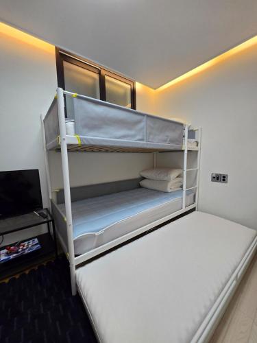 a bedroom with a bunk bed and a television at Santiago 2nd in Busan