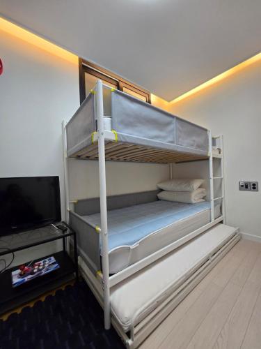 a bedroom with two bunk beds and a television at Santiago 2nd in Busan