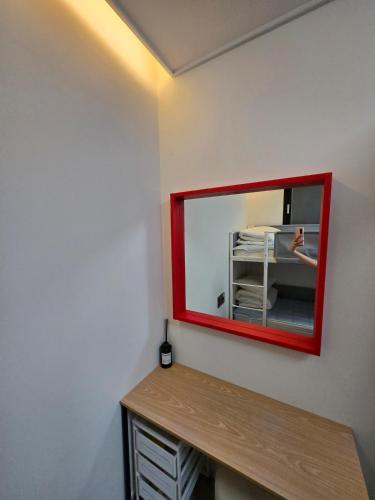 a mirror with a red frame on a wall at Santiago 2nd in Busan