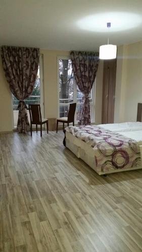 1 dormitorio con 1 cama, sillas y ventanas en Park View Studios, en Sandanski