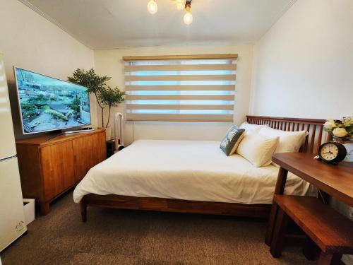 Un dormitorio con una cama y un televisor de pantalla plana. en 다온 영등포 Daon Youngdeungpo accommodation, en Seúl