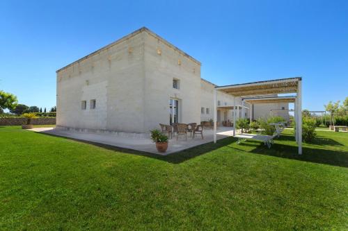 a large yard with a white building and grass at B&B Agricola Bellisario Ospitalità Rurale, Alimini Otranto in Conca Specchiulla