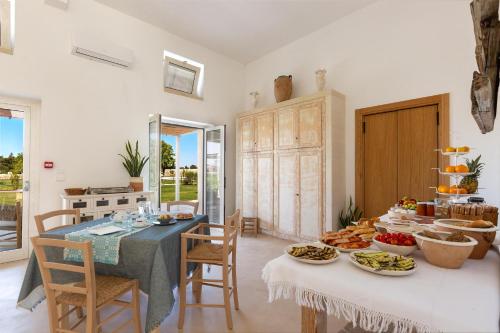 a dining room with a table with food on it at B&B Agricola Bellisario Ospitalità Rurale, Alimini Otranto in Conca Specchiulla