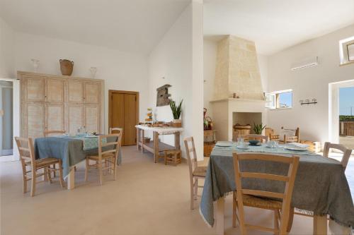 a dining room with two tables and chairs at B&B Agricola Bellisario Ospitalità Rurale, Alimini Otranto in Conca Specchiulla