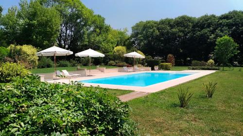 a swimming pool in a yard with umbrellas at Villa Zane in Treviso