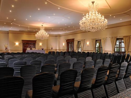 a large room with chairs and chandeliers at Hotel Woodstock Ennis in Ennis