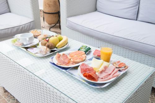 a table with two plates of food and drinks on it at Hostal Residencia Europa Punico in Ibiza Town