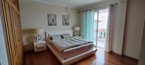 ein Schlafzimmer mit einem Bett und einem großen Fenster in der Unterkunft VillaMadeira Basement Apartment in Funchal in Funchal