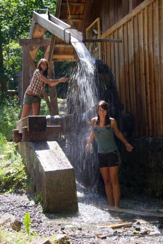 two women standing next to a water fountain at Haus Lackner am Weissensee in Kärnten in Weissensee