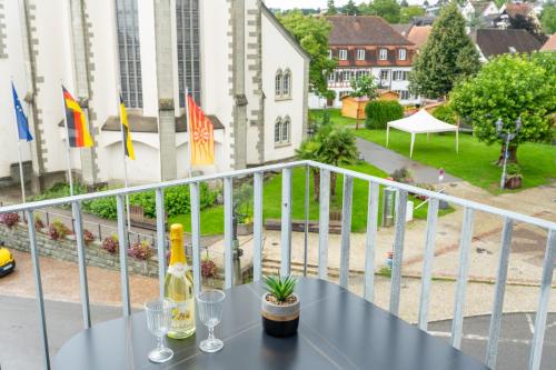 a table with wine glasses on a balcony with flags at Das Adler in Markdorf