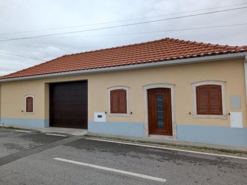 a house with two garage doors on a street at Casa do Avô Carriço in Cantanhede
