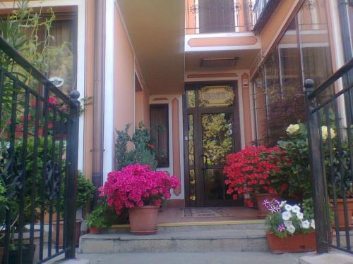 a front door of a house with pots of flowers at Hotel Alafrangite in Plovdiv